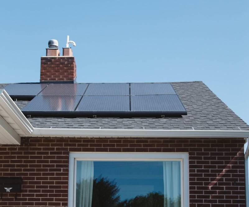 brown brick house with solar panels on roof