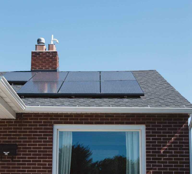brown brick house with solar panels on roof