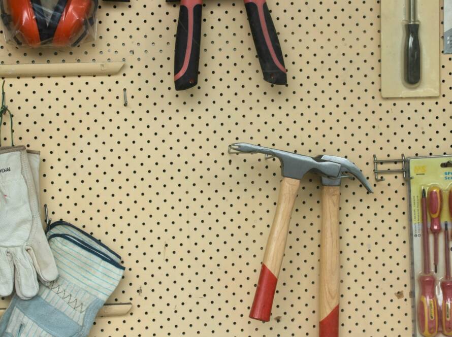 black and silver claw hammer beside red and black hand tool
